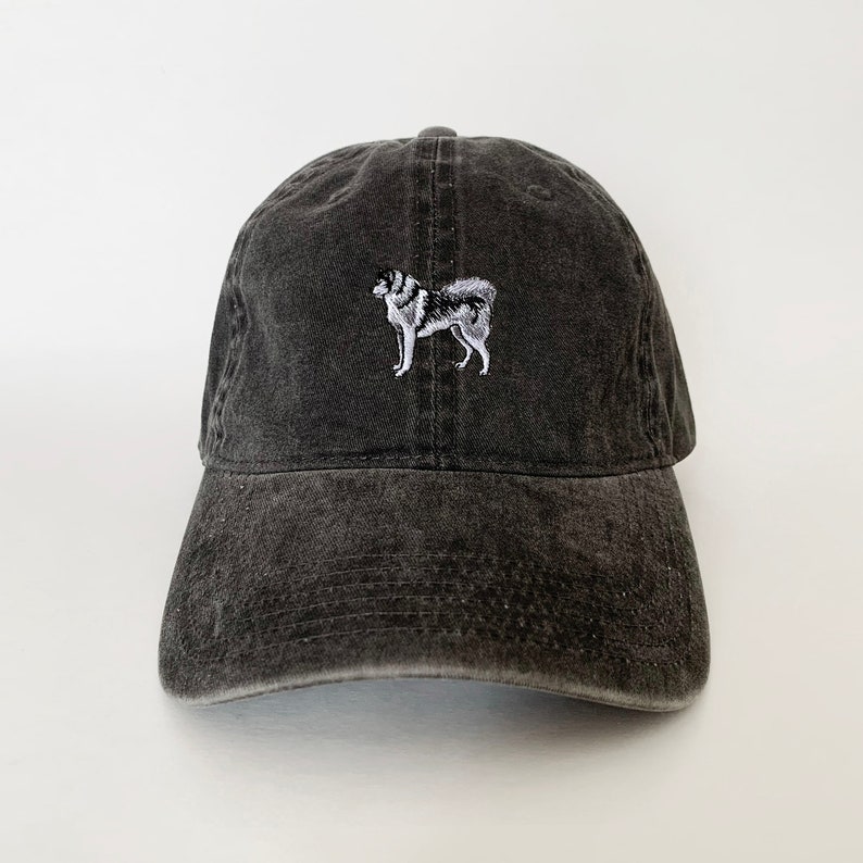 May include: A black, distressed, cotton baseball cap with an embroidered image of a white and gray husky dog.