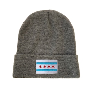 May include: Gray knit beanie with a white patch featuring the Chicago flag with red stars.