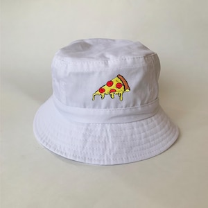 May include: White bucket hat with a pizza slice embroidered on the front. The pizza slice has red pepperoni, yellow cheese, and a brown crust. The hat is made of a soft, durable fabric.