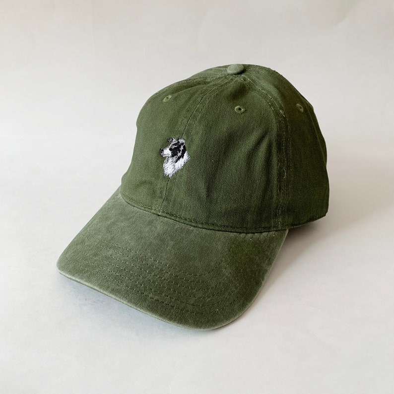 Puede incluir: Una gorra de b&eacute;isbol verde con una imagen bordada de la cabeza de un perro en la parte delantera.