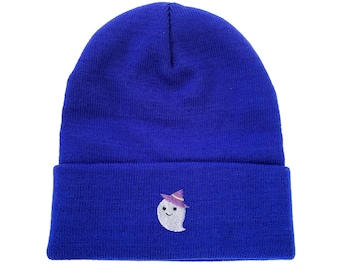 Puede incluir: Un gorro de punto azul real con borde doblado. El gorro presenta un fantasma bordado con un sombrero de bruja morado. El fantasma tiene una cara sonriente. Un accesorio divertido para Halloween o cualquier época del año.