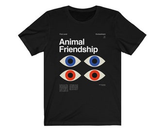 May include: Black t-shirt with white text that reads "First Level Animal Friendship Enchantment". The design features four stylized eyes with blue, red, and white colors.