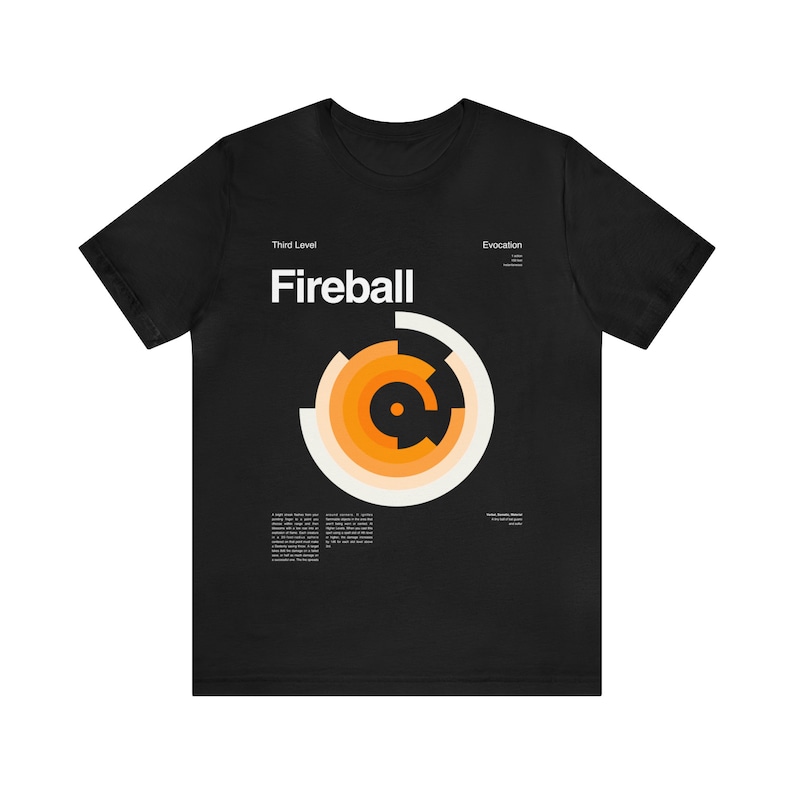 Puede incluir: Camiseta negra con un dise&ntilde;o gr&aacute;fico blanco de un c&iacute;rculo con anillos conc&eacute;ntricos en naranja y blanco. El texto "Fireball" est&aacute; por encima del c&iacute;rculo y los textos "Third Level" y "Evocation" est&aacute;n por encima y por debajo del c&iacute;rculo, respectivamente.