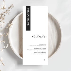 Może przedstawiać: Biała prostokątna karta menu z czarnym tekstem o treści SLOAN REYNOLDS i menu. Lista zawiera Caesar Salad with avocado, crouton, parmesan, Pan Seared Sea Scallops with shallot, micro arugula, pea puree oraz Dark Chocolate Mousse.