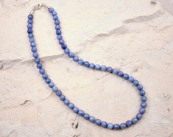 May include: A light blue gemstone necklace with a silver clasp. The necklace is made of round beads and is approximately 18 inches long.