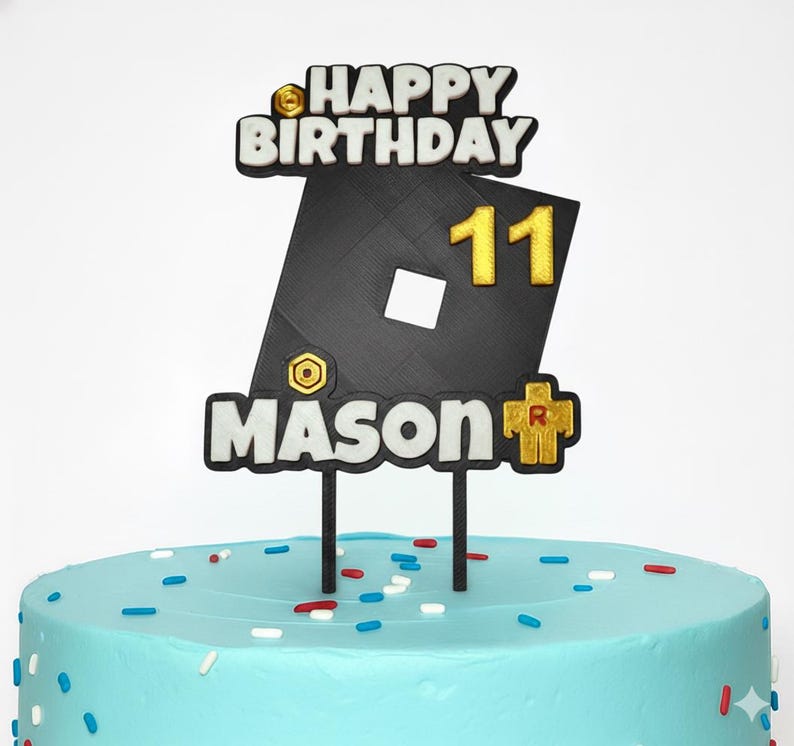 May include: A cake topper with the words "HAPPY BIRTHDAY" and the number "11" in gold. The name "MASON" is also displayed. The cake is light blue with colorful sprinkles.