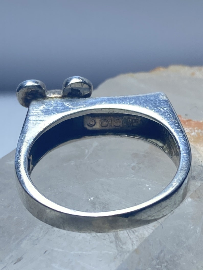 Puede incluir: Anillo de plata con un dise&ntilde;o de cabeza de Mickey Mouse. El anillo est&aacute; marcado con el texto "&copy; Disney".