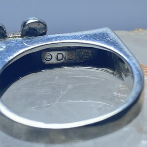 Puede incluir: Un anillo de plata con un dise&ntilde;o de Mickey Mouse. El anillo est&aacute; inscrito con el s&iacute;mbolo de copyright y la palabra "DISNEY".