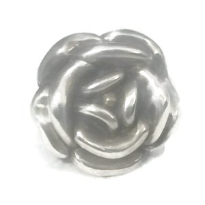 May include: A silver charm in the shape of a rose. The rose is made of intertwined petals.