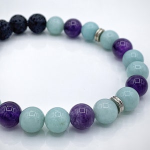 May include: A beaded bracelet featuring black lava rock, amethyst, and aquamarine beads.