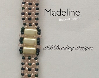 Op de afbeelding: Een close-up van een kralenarmband met een patroon van roze en groene kralen. De armband heeft een decoratief element in het midden met drie witte kralen. De tekst "Madeline Bracelet Pattern" en "DB Beading Designs" is zichtbaar in de afbeelding.
