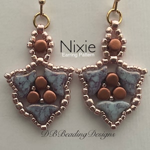 Op de afbeelding: Een paar oorhangers met een geometrisch ontwerp. De oorhangers zijn gemaakt van kleine, lichtroze kralen en koperkleurige kralen. De oorhangers zijn gevormd als een schild met een driehoek in het midden. De oorhangers zijn gelabeld met "Nixie Earring Pattern" en "DB Beading Designs".