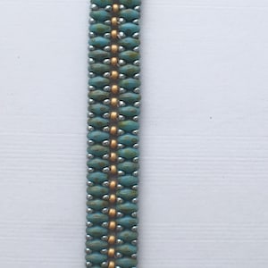 May include: A turquoise and gold beaded bracelet with a silver clasp. The bracelet is made with small, round beads and has a simple, elegant design.