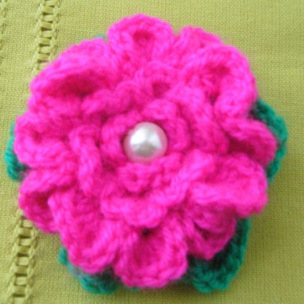 Cadeau - Broche faite main au crochet - fleur en laine acrylique fuchsia et verte ornée d'une perle nacrée cousue