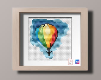 May include: A framed cross-stitch design of a colorful hot air balloon floating in a blue sky. The balloon is made of rainbow colors and has a basket underneath. The design is surrounded by a white border.