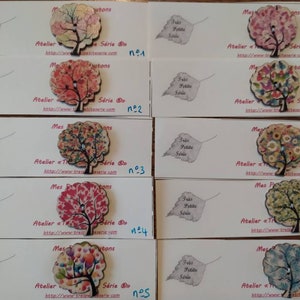 Puede incluir: Diez botones de madera con un diseño de árbol. Cada botón presenta un patrón floral colorido diferente. Los botones están numerados del 1 al 10.