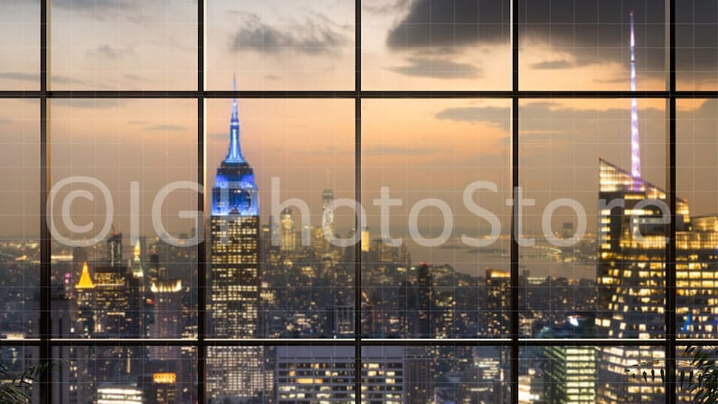 Puede incluir: Una vista de un horizonte urbano al atardecer a trav&eacute;s de una gran ventana con m&uacute;ltiples paneles. La ciudad est&aacute; iluminada con luces y el cielo es de un suave naranja y morado. El Empire State Building es visible en el centro de la imagen.