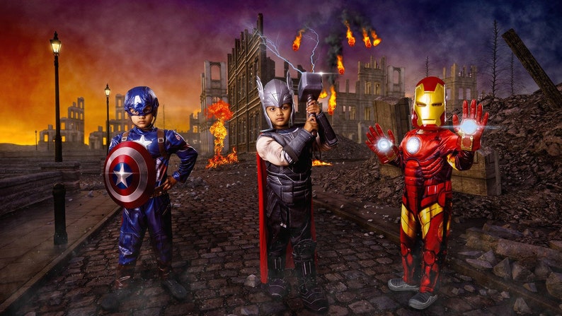 Peut inclure: Trois enfants costum&eacute;s en super-h&eacute;ros posent dans un d&eacute;cor de guerre. Captain America en bleu, Thor avec un marteau et Iron Man en rouge et or avec des effets lumineux sur les mains. Ambiance dramatique.