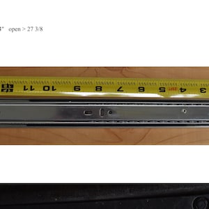 May include: A silver drawer slide with a yellow measuring tape showing it is 14 inches long. The text "wt 14 oz ea closed 14" open > 27 3/8" is visible in the image.