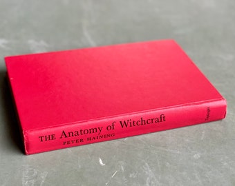 May include: A red hardcover book titled "THE Anatomy of Witchcraft" by PETER HAINING.