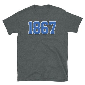 May include: A dark heather grey t-shirt with a blue and white number "1867" printed on the front.