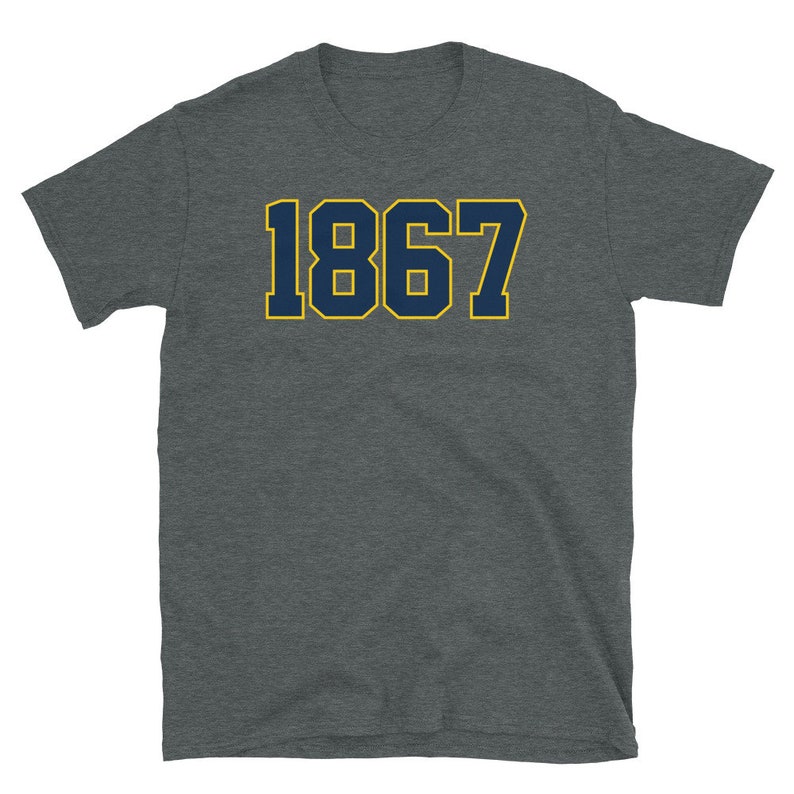 Może przedstawiać: Szary t-shirt z nadrukiem cyfry "1867" w kolorze granatowym z ż&oacute;łtym obramowaniem.