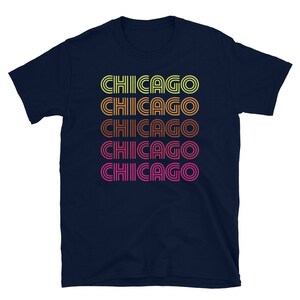 May include: Navy blue t-shirt with the word "CHICAGO" repeated five times in a retro, multi-colored, striped font.
