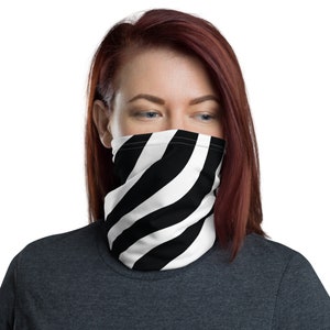 May include: A black and white striped face mask with a diagonal pattern. The mask is made of a soft, breathable fabric and is designed to be comfortable to wear.