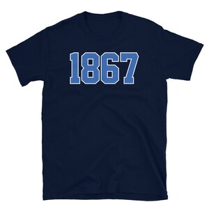 May include: Navy blue t-shirt with the number 1867 printed in white on the front.
