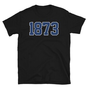 Puede incluir: Camiseta negra de manga corta con el n&uacute;mero 1873 impreso en azul en la parte delantera.