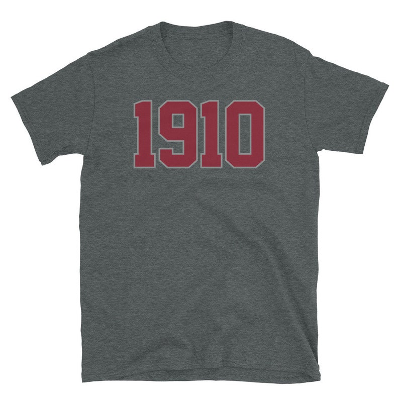May include: A dark heather grey t-shirt with a red 1910 printed on the front.