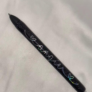 May include: A black glitter pen with silver lettering that says "Forever" with a heart symbol.