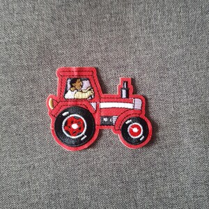 Peut inclure: Un écusson de tracteur rouge avec des pneus noirs et un conducteur visible dans la cabine. Le patch a des accents dorés et blancs. Le tracteur est un design brodé amusant.