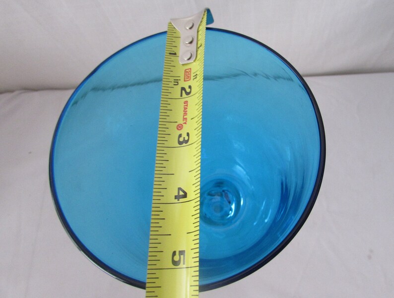 K&ouml;nnte beinhalten: Eine leuchtend blaue Glasschale mit kreisf&ouml;rmiger &Ouml;ffnung, von oben betrachtet. Ein gelbes Stanley-Ma&szlig;band liegt &uuml;ber der Mitte und zeigt einen Durchmesser von etwa 13,3 cm f&uuml;r den breiten Rand der Schale an.