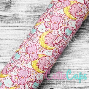 May include: Pink and white fabric with a repeating pattern of cartoon cats sleeping on yellow moons. The fabric is covered in small white stars and clouds.