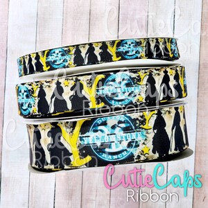 May include: Close-up of a black and yellow ribbon with a repeating pattern of cowboys riding horses and a blue and white stamp that says "The First State Ranch".