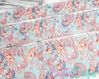 May include: Bluey and Bingo cartoon character ribbon with a light blue background, rainbows, and white flowers. The ribbon has the words "Bluey" printed on it.