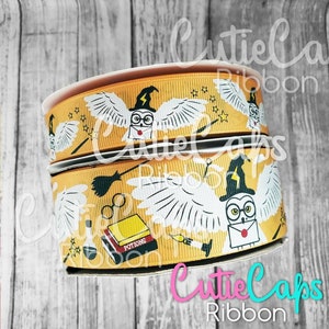 May include: Two spools of yellow and white ribbon with a Harry Potter theme. The ribbon features owls, wands, glasses, and the words "Potions".