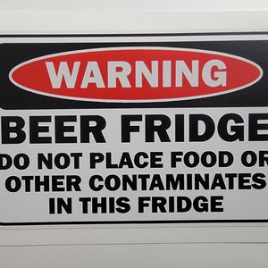 May include: A black and white warning sign with red text that reads "WARNING" in a red oval. The sign says "BEER FRIDGE DO NOT PLACE FOOD OR OTHER CONTAMINATES IN THIS FRIDGE".