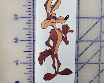 May include: A cartoon coyote with brown fur, a black nose, and a sly expression. The coyote is standing with its right paw raised and its left paw on the ground. The coyote is looking to the right.