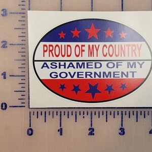 May include: A white oval sticker with a red, white and blue design. The sticker says "Proud of my country, ashamed of my government".