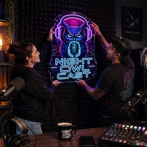 May include: A rectangular neon sign featuring a stylized purple and blue owl wearing headphones and positioned above a microphone. The text NIGHT OWL CAST is illuminated in bright blue neon letters below the owl graphic on a clear acrylic backing.