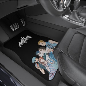 Puede incluir: Alfombrillas de coche negras con un gr&aacute;fico de un grupo de personajes de anime de la serie Nana. Las alfombrillas muestran la palabra "NANA" en una fuente estilizada.