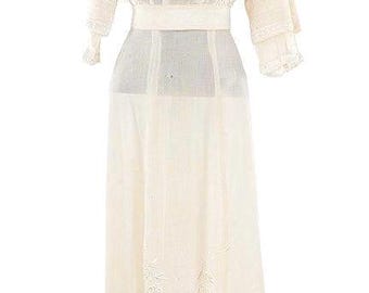 May include: Cream-colored vintage dress with intricate floral embroidery. The dress features a high neckline, long sleeves with lace cuffs, and a fitted waist. The skirt is floor-length and also has floral embroidery.