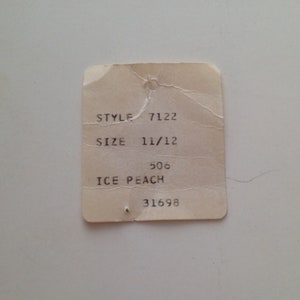 Może przedstawiać: Biała metka z czarnym tekstem, na kt&oacute;rej widnieje "STYLE 7122", "SIZE 11/12", "506 ICE PEACH" i "31698".