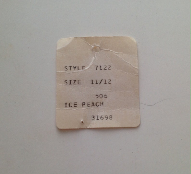 Może przedstawiać: Biała metka z czarnym tekstem, na kt&oacute;rej widnieje "STYLE 7122", "SIZE 11/12", "506 ICE PEACH" i "31698".