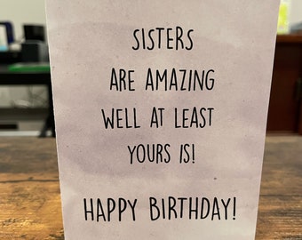 Może przedstawiać: Biała kartka z szarym akwarelowym tłem i czarnym tekstem, który brzmi "Sisters are amazing well at least yours is! Happy Birthday!"