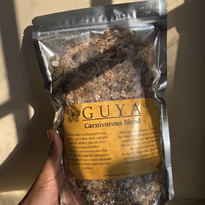 Könnte beinhalten: Ein klarer Plastikbeutel gefüllt mit einer Mischung für fleischfressende Pflanzen. Auf dem Beutel befindet sich ein gelbes Etikett mit der Aufschrift "GUYA Carnivorous Blend". Die Mischung besteht aus Sphagnummoos, Perlite und Rinde.