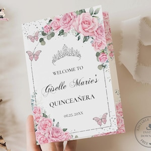 Könnte beinhalten: Eine weiße und rosafarbene Quinceañera-Einladung mit floralem Design. Die Einladung zeigt eine Krone, Schmetterlinge und den Text "Willkommen zu Giselle Marie's Quinceañera 06.25.20XX".