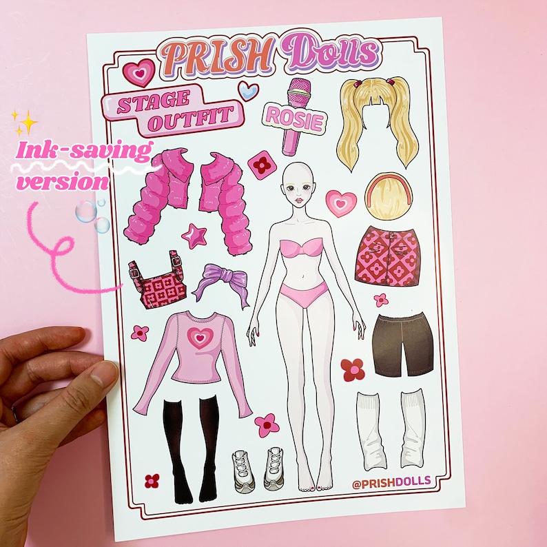 May include: A pink and white paper doll set with the text "PRISH Dolls" and "STAGE OUTFIT" in pink. The set includes a doll, clothing, accessories, and a microphone labelled "ROSIE".